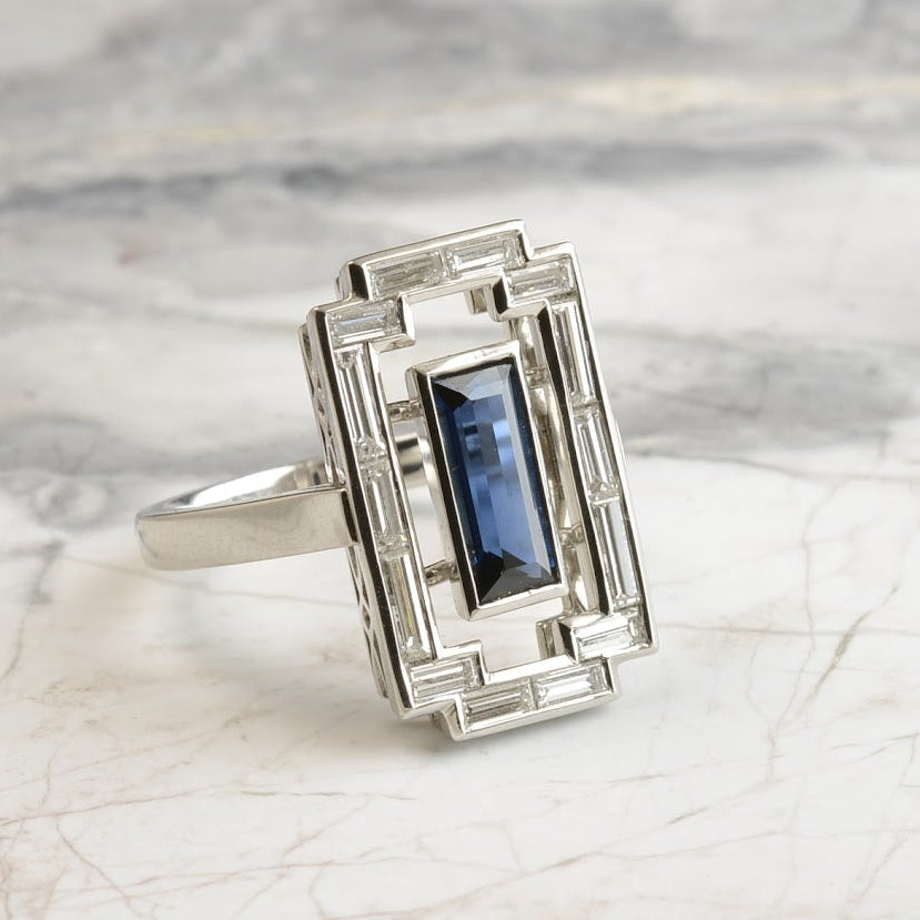 Art Deco-style platinum ring with a baguette-cut Australian sapphire centrepiece flanked by baguette-cut diamonds and arranged in a filigree basket. Handmade by Sydney jeweller Nicky Burles.