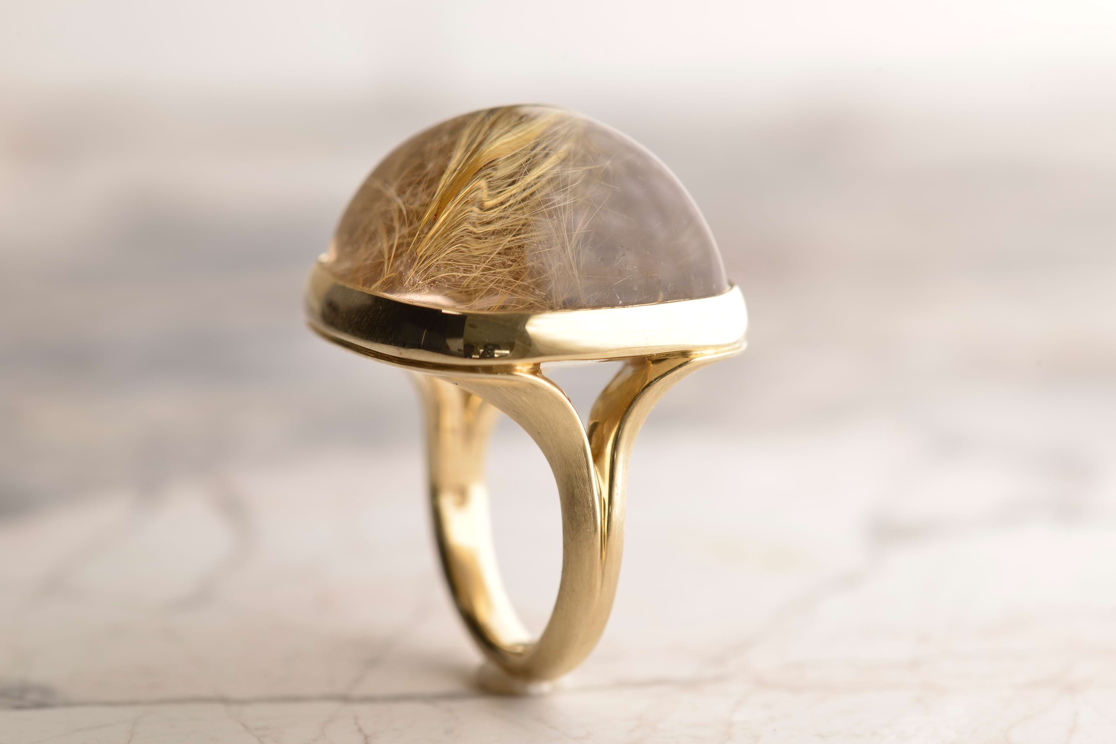 9ct yellow gold ring featuring a 50-carat rutilated quartz with luminous titanium dioxide inclusions, set on a satin-finished shank. Handmade by Sydney jeweller Nicky Burles.