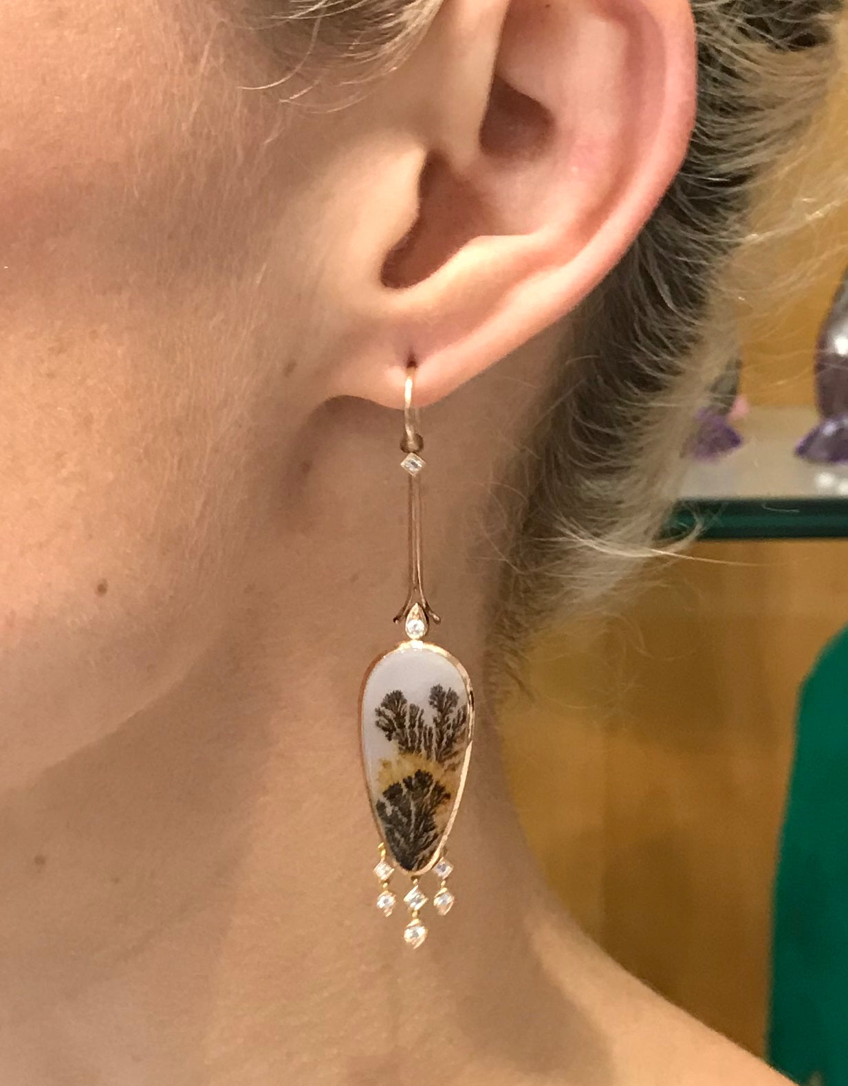 Wearing bespoke 18ct rose gold earrings featuring dendritic agate stones, accented with diamond tassels. Handmade by Sydney jeweller Nicky Burles.