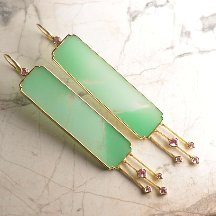 Earrings featuring semi translucent Australian Chrysoprase tablets with a gentle colour shift from green to blue and back again, and clear inclusions.
Set in 18 ct gold and with pastel pink Ceylon sapphire tassel detail. Handmade by Sydney jeweller Nicky Burles.