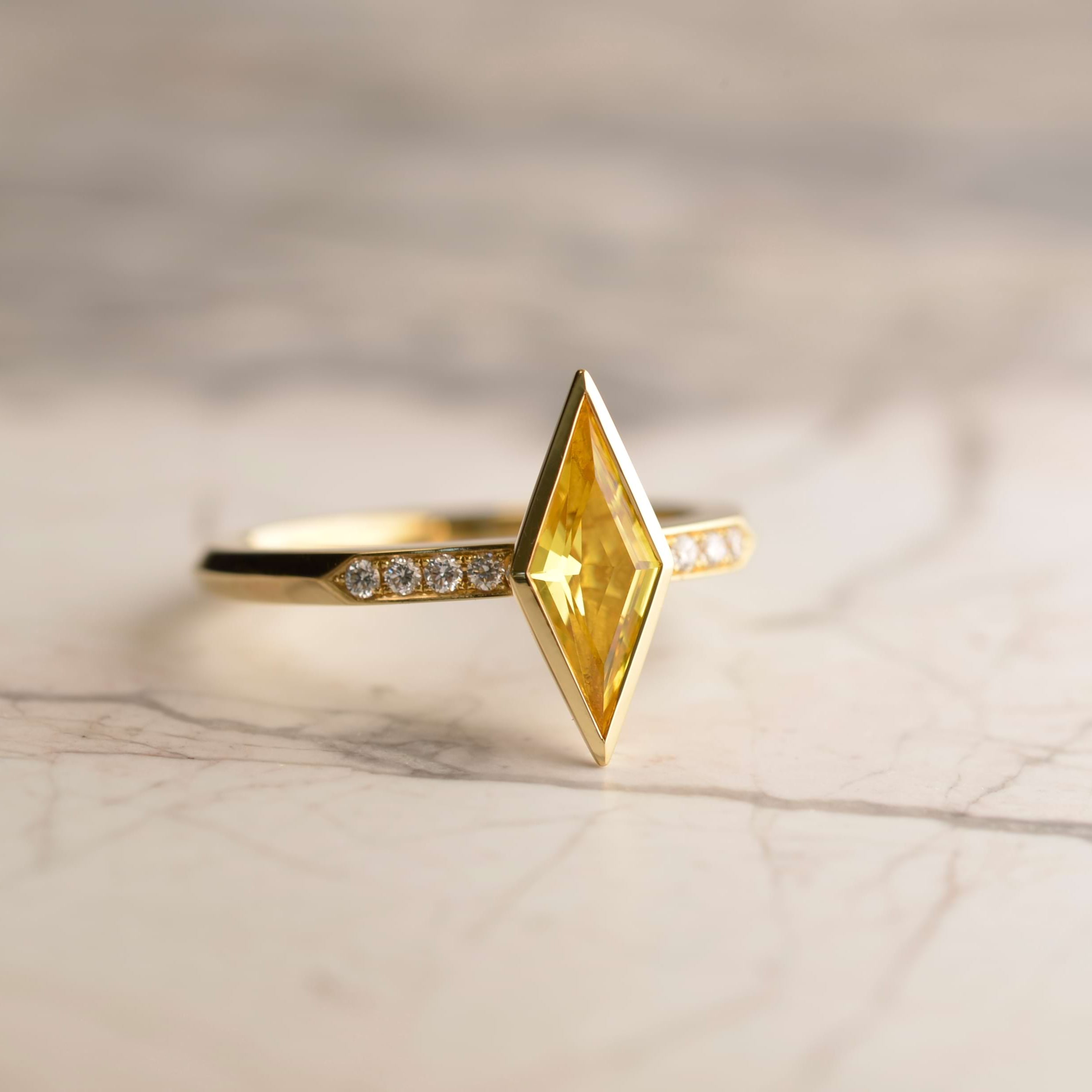 Diamond cut 0.8ct richly saturated golden Australian sapphire flanked 8 diamonds along the shoulder of this 18ct gold bespoke ring. Handmade by Sydney jeweller Nicky Burles